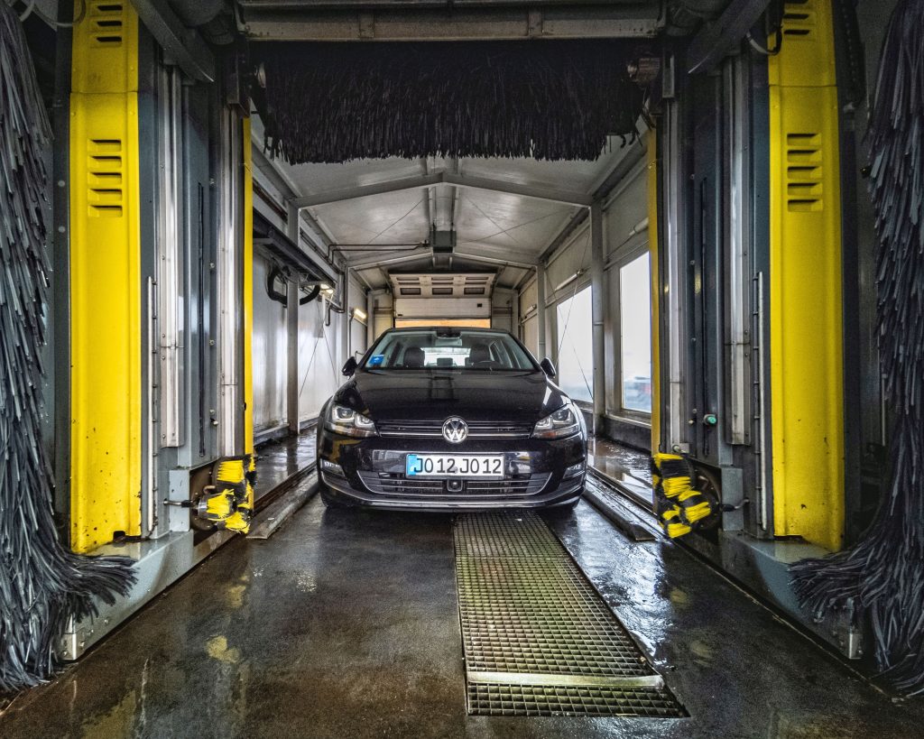 A black car undergoing a thorough cleaning in an automated car wash facility. best car buffer